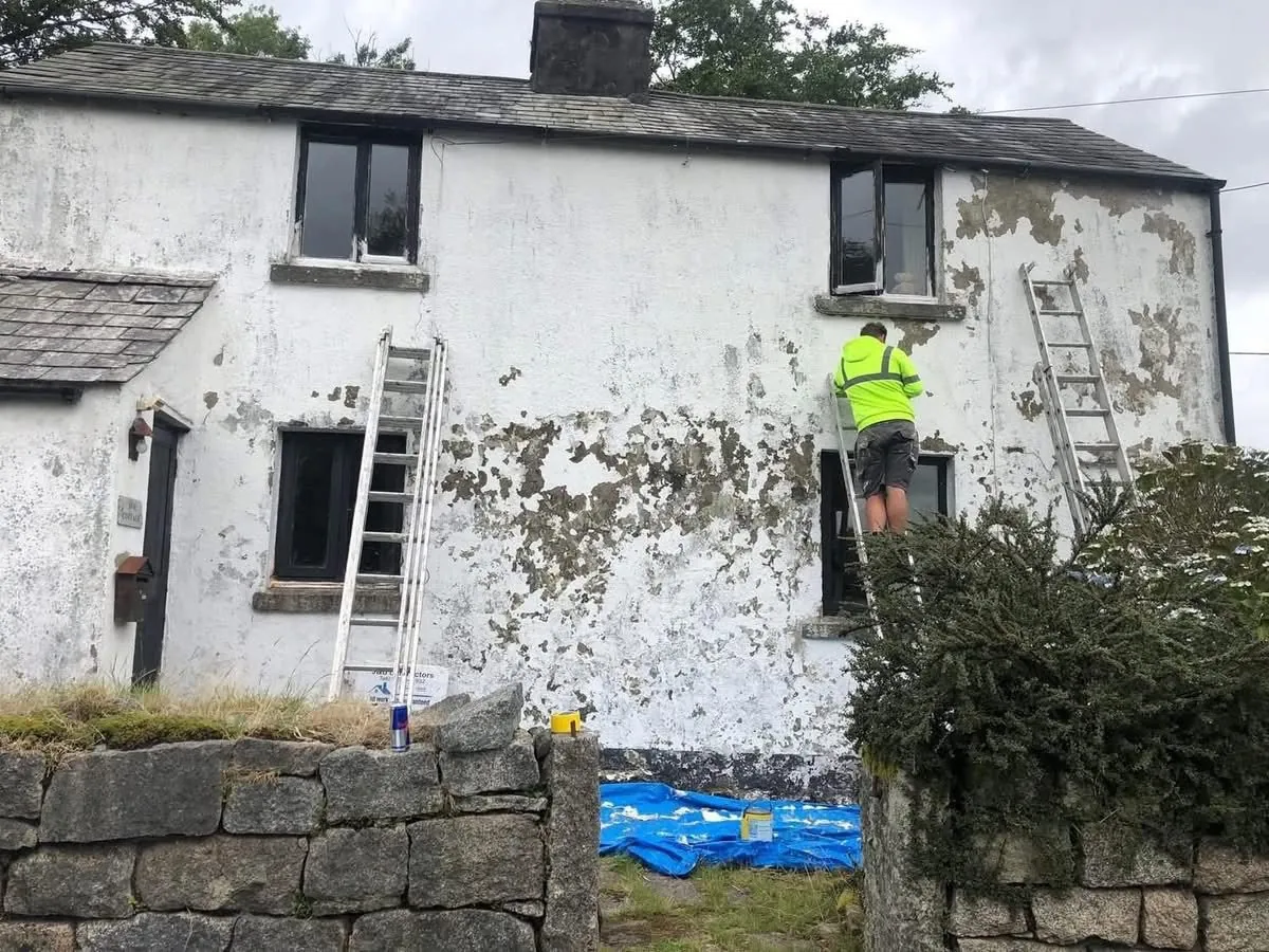 Cottage with blown, flaking render before repair in Mullion